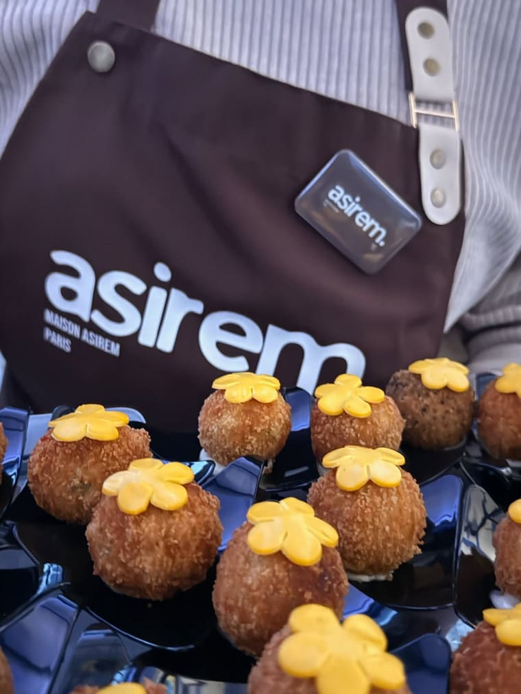 Bouchées croustillantes dressées à l’assiette, présentées par un membre de l’équipe en tablier Maison Asirem